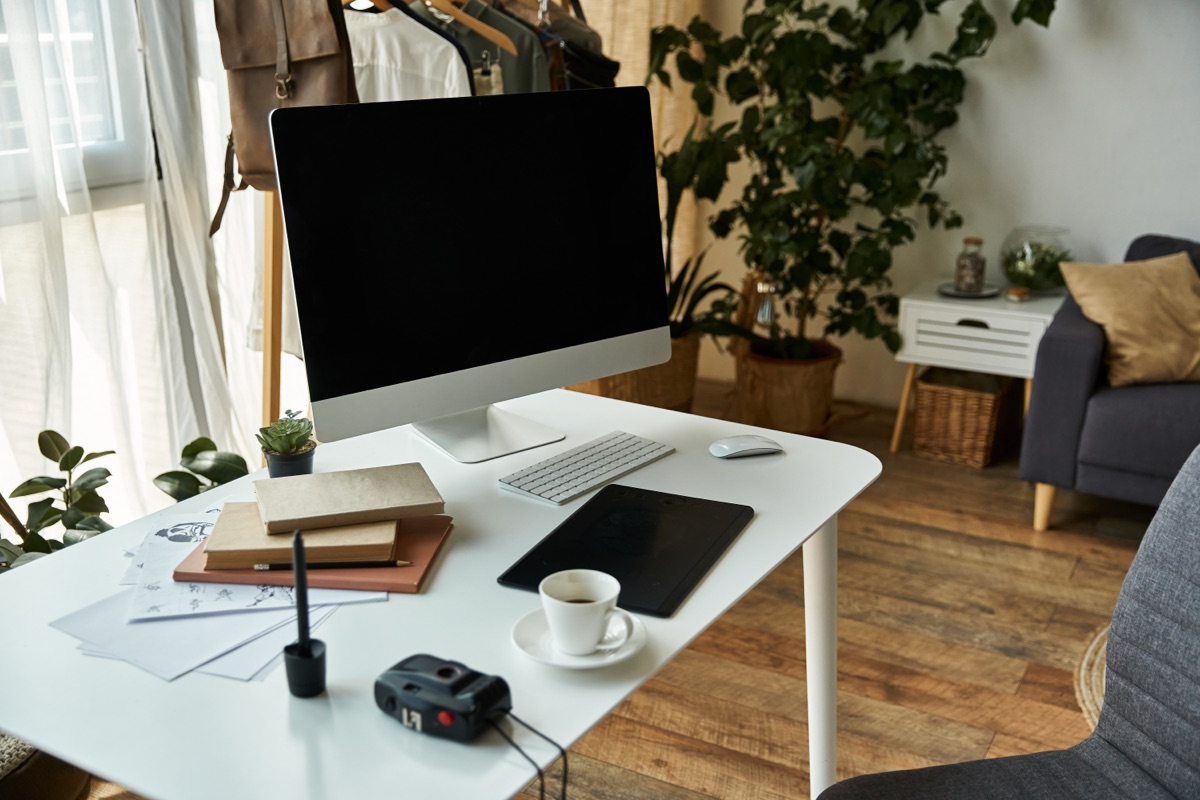 A bright home office with a window, plants and a tidy desk
