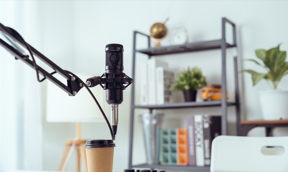 Over-ear headphones and a boom-arm microphone beside a desk