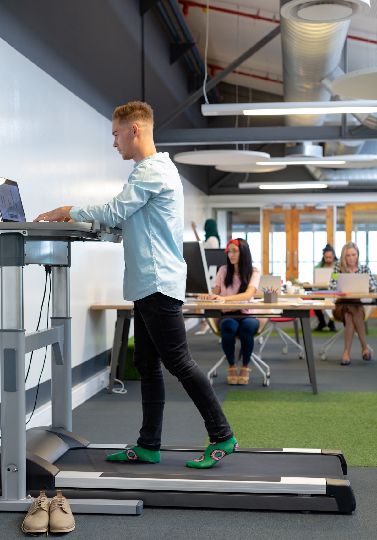 An under-desk treadmill in front of a standing desk
