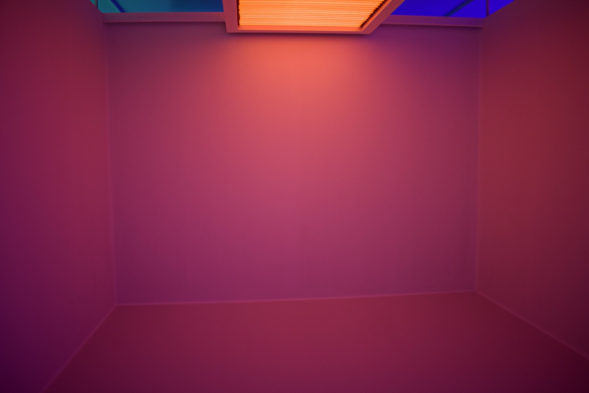 Purple-pink gradient wall lit by neon orange and blue ceiling lights