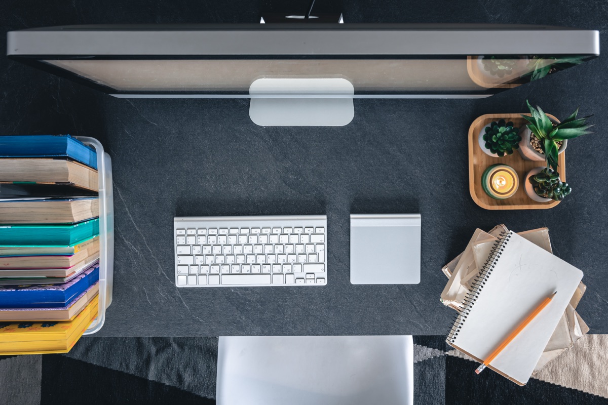 A developer workspace with a monitor, keyboard and desk lamp